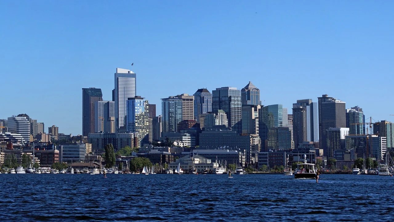 Seattle buildings seen across the blue water of Lake Union with small boats in the foreground